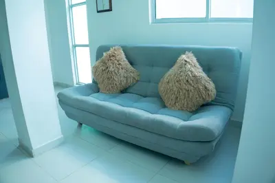 a blue couch with two pillows on it at Boquillas del Mar - Apartamentos in Cartagena de Indias
