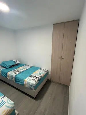 a bedroom with a bed and a wooden cabinet at Moderno Apartamento en Barranquilla, Miramar in Barranquilla