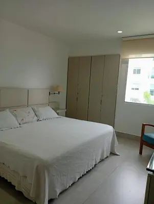 a bedroom with a large white bed and a window at Apartamento en la Boquilla Cartagena in Cartagena de Indias