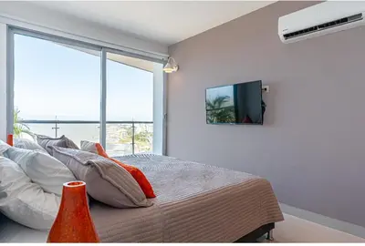 a bedroom with a bed and a tv on the wall at Altamar, disfruta la mejor vista in Cartagena de Indias
