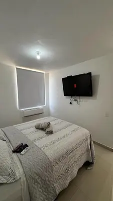 a bedroom with a bed with a flat screen tv on the wall at Apartamento con Vista espectacular en Barranquilla in Barranquilla