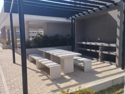 a picnic table and bench under a blue umbrella at Apartamento con Vista espectacular en Barranquilla in Barranquilla