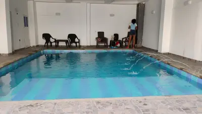 a pool with chairs and a person standing in a room at Safariplaya in Cartagena de Indias