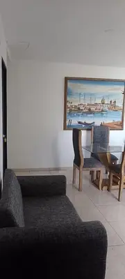 a living room with a piano and a painting of a harbor at Safarihostal in Cartagena de Indias