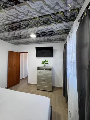 a room with a bed and a tv on a ceiling at Apartamentos el mochilero frente al mar piso 2 apto 3 in Cartagena de Indias