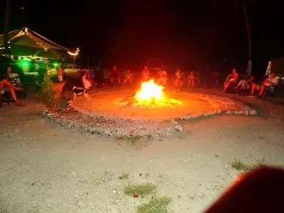 a large fire pit with people sitting around it at night at Tintipán Glamping in Tintipan Island