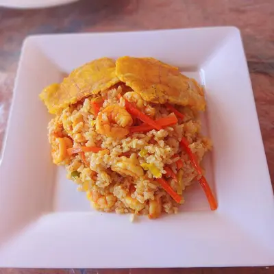 a white plate with a rice dish with shrimp and vegetables at Tintipán Glamping in Tintipan Island