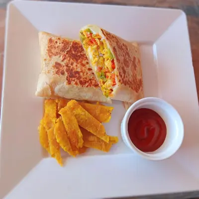 a white plate with a sandwich and chips and ketchup at Tintipán Glamping in Tintipan Island