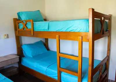 two bunk beds in a room with blue sheets at Alojamiento Familiar #2 - La mejor playa y mar in Puerto Viejo