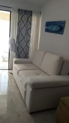 a white couch in a living room with a window at cartagena balcon con vista al mar in Cartagena de Indias