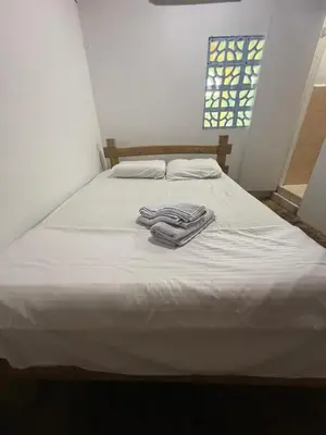 a white bed with a pile of towels on it at Espectacular cabaña frente al mar in Paso Nuevo