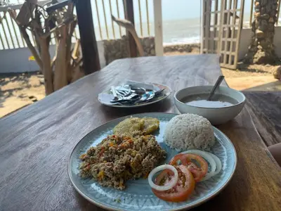 a plate of food with rice and tomatoes on a table at Espectacular cabaña frente al mar in Paso Nuevo