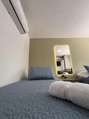 a bedroom with a large bed and a mirror at Loft Deluxe - Nuevo, Acogedor, Integral, Ubicación inmejorable in Barranquilla