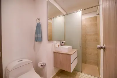 a bathroom with a toilet and a sink and a mirror at Beachfront Studio with Stunning Ocean Views in Cartagena de Indias