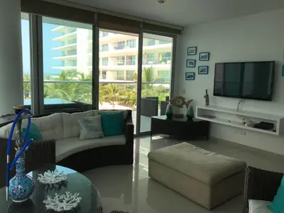 a living room with a couch and a tv at Morros Suites Apartamentos in Cartagena de Indias