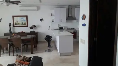 a kitchen and living room with a table and a dining room at Morros Suites Apartamentos in Cartagena de Indias