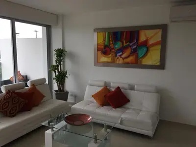 a living room with a white couch and a glass table at Morros Suites Apartamentos in Cartagena de Indias