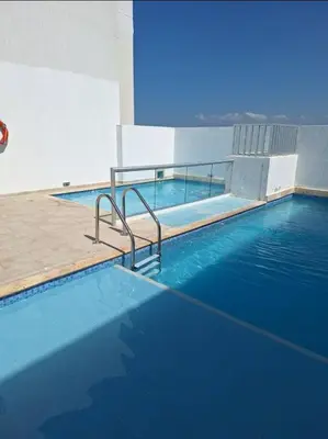 a swimming pool with blue water in a building at Cozy & Nice Cartagena apartment near to the beach in Cartagena de Indias