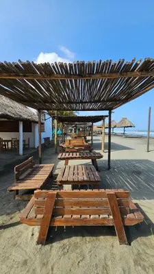 a group of wooden benches sitting on the beach at PalMar Ecolodge in Moñitos