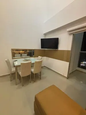a dining room with a table and chairs and a flat screen tv at Apartamento Magno Loft Bocagrande in Cartagena de Indias
