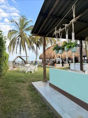 a restaurant with tables and chairs on the beach at Cabaña Las Tres Palmas in San Bernardo del Viento in San Bernardo del Viento