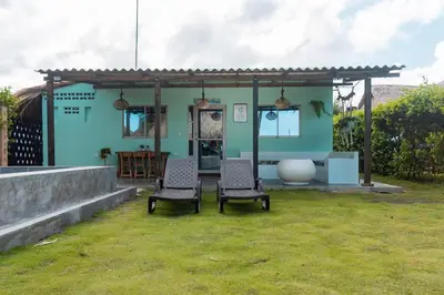 a blue house with two chairs in a yard at Cabaña Las Tres Palmas in San Bernardo del Viento in San Bernardo del Viento