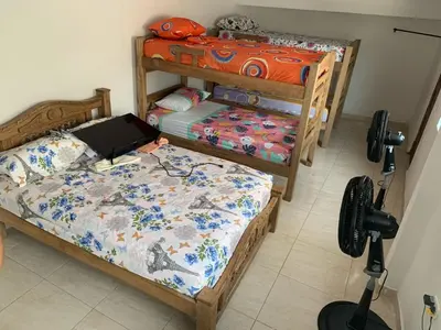 a bedroom with three bunk beds with a laptop on it at Hostal La FLora in Cartagena de Indias