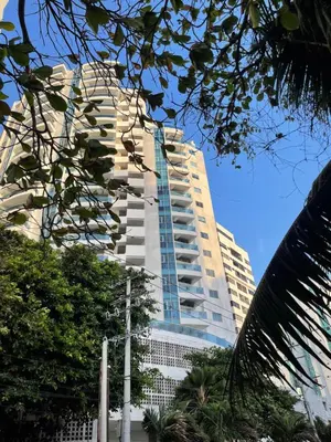 a tall white building with windows and trees at Apartamento a 1 minuto de la playa in Cartagena de Indias