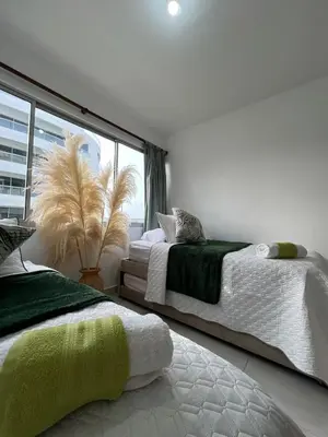 two beds in a room with a window at Serenity Flat in Puerto Tierrabaja