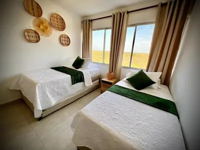 two beds in a room with a window at cartagena apto castelo serena del mar in Puerto Tierrabaja