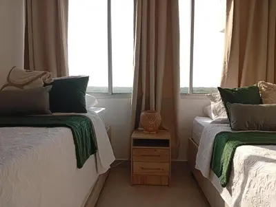 two beds in a room with two windows at cartagena apto castelo serena del mar in Puerto Tierrabaja