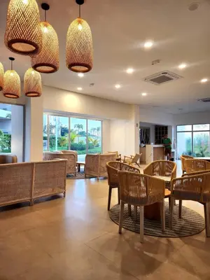 a dining room with tables and chairs and windows at Con jacuzzi privado, laguna y Paddle board in Cartagena de Indias