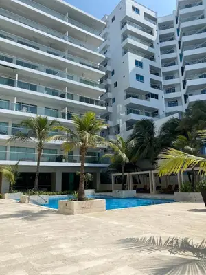 a large apartment building with palm trees and a swimming pool at U-GO Morros epic in Cartagena de Indias
