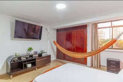 a bedroom with a bed and a hammock in a room at Habitaciones cerca playa Bocagrande in Cartagena de Indias