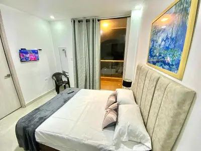 a bedroom with a large bed and a couch at Casa balcones del rio in Barranquilla