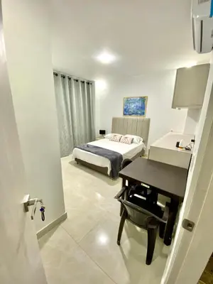a bedroom with a bed and a desk and a piano at Casa balcones del rio in Barranquilla