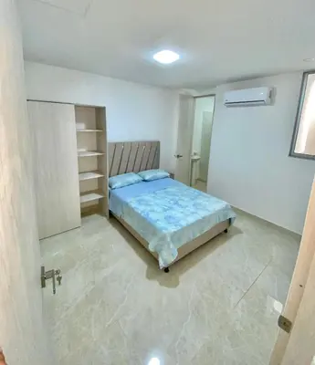 a bedroom with a bed in a white room at Casa balcones del rio in Barranquilla