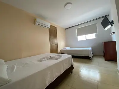 a hotel room with two beds and a window at Hotel Prado Cartagena in Cartagena de Indias