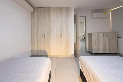 a bedroom with two beds and a cupboard at Cozy apartment in bocagrande in Cartagena de Indias