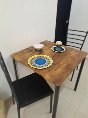 a wooden table with two cups and plates on it at Apartaestudio completo cerca Barranquilla in Galapa