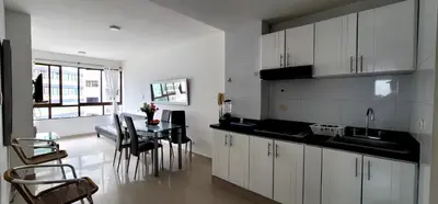 a kitchen with white cabinets and a table with chairs at Live Stay - Cartagena Escape Plaza in Cartagena de Indias