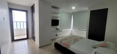a bedroom with a bed and a television and a window at Live Stay - Cartagena Escape Plaza in Cartagena de Indias