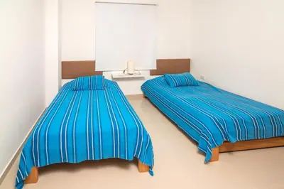 two beds in a room with blue sheets at Hermoso Apartamento Frente al Mar 3 Habitaciones B62 in Coveñitas