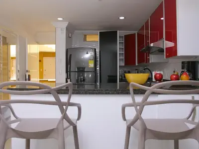 a kitchen with red cabinets and two chairs at Historic Cartagena 2BR Apt in Cartagena de Indias