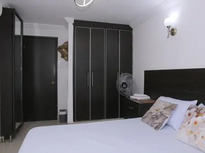 a bedroom with a large white bed and black cabinets at Historic Cartagena 2BR Apt in Cartagena de Indias
