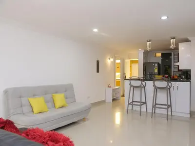 a living room with a couch and a kitchen at Historic Cartagena 2BR Apt in Cartagena de Indias
