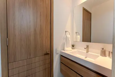 a bathroom with a sink and a wooden door at Baia Kristal in Cartagena de Indias