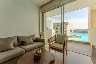 a living room with a couch and a table and a large window at Baia Kristal in Cartagena de Indias