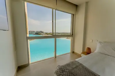 a bedroom with a large window with a view of the ocean at Baia Kristal in Cartagena de Indias