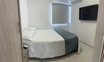 a bedroom with a bed and a flat screen tv at Hermoso apto, cerca al mar in Cartagena de Indias